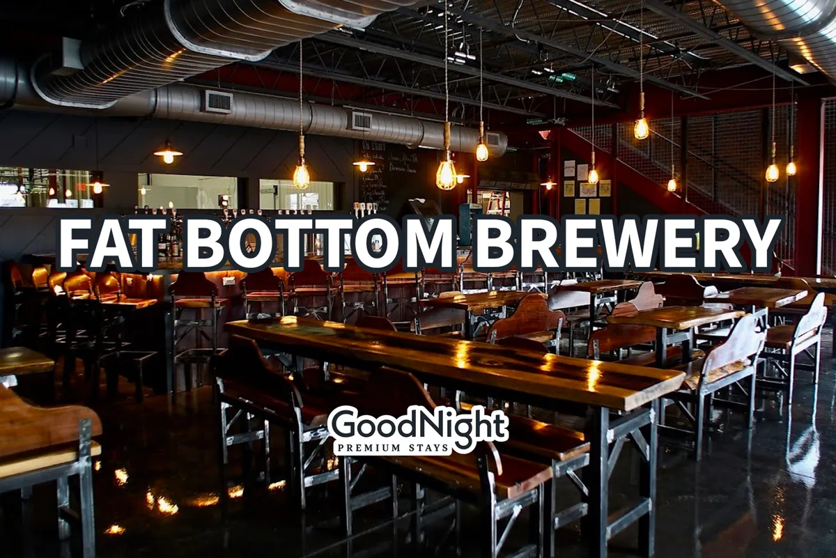 A lively interior scene featuring long wooden tables, a bustling bar area with stools, and hanging light fixtures. The atmosphere is communal and energetic, reminiscent of a popular brewery or eatery. People can be imagined socializing, tasting craft beers, and enjoying themed dinners.